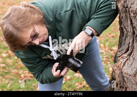 Femme prenant une photo en gros plan d'un arbre Banque D'Images