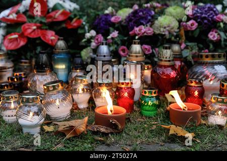 Des bougies et des lanternes sont placées près de la tombe le jour de la Toussaint au cimetière évangélique d'Augsbourg à Varsovie. La Toussaint (ou Dzie ? Zaduszny en polonais) est un jour férié en Pologne. C’est l’occasion de se souvenir de parents décédés. Ce jour-là, les gens apportent des fleurs, généralement des chrysanthèmes, et des bougies aux cimetières. Tout le cimetière est rempli de lumières dans l'obscurité. Le cimetière évangélique d'Augsbourg est un cimetière protestant luthérien historique situé dans la partie ouest de Varsovie. Depuis son ouverture en 1792, plus de 100 000 personnes y ont été enterrées. Banque D'Images