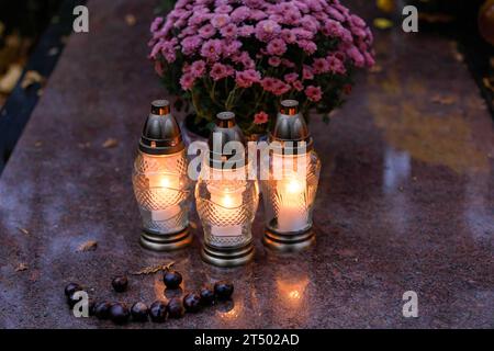 Des bougies sont placées sur la tombe le jour de la Toussaint au cimetière évangélique d'Augsbourg à Varsovie. La Toussaint (ou Dzie ? Zaduszny en polonais) est un jour férié en Pologne. C’est l’occasion de se souvenir de parents décédés. Ce jour-là, les gens apportent des fleurs, généralement des chrysanthèmes, et des bougies aux cimetières. Tout le cimetière est rempli de lumières dans l'obscurité. Le cimetière évangélique d'Augsbourg est un cimetière protestant luthérien historique situé dans la partie ouest de Varsovie. Depuis son ouverture en 1792, plus de 100 000 personnes y ont été enterrées. Banque D'Images