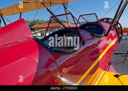 Vue intérieure d'un cockpit ouvert sur un biplan vintage magnifiquement restauré garé dans un petit aéroport exposé par une journée ensoleillée Banque D'Images