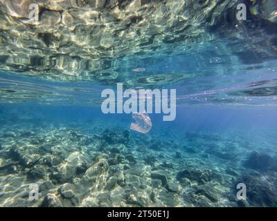 Sac en plastique blanc flottant dans la mer. Pollution de l'environnement. Banque D'Images