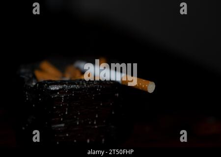 cigarette égarée sur fond noir Banque D'Images