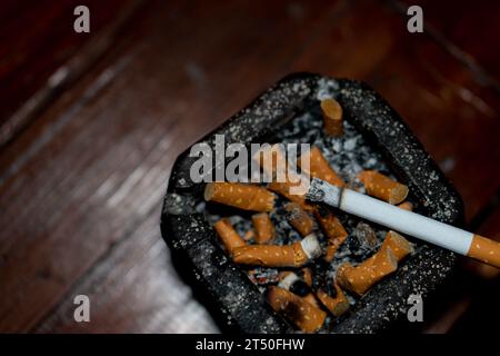 cigarette égarée sur fond noir Banque D'Images