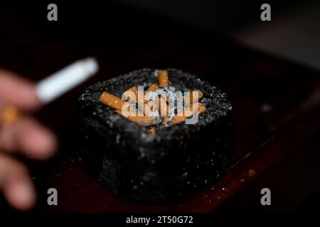 cigarette égarée sur fond noir Banque D'Images