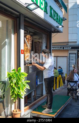 Istanbul, Turquie, Un employé de sexe masculin coupant un kebab dans un restaurant, éditorial seulement. Banque D'Images