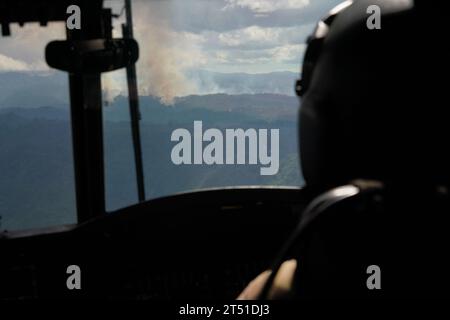 Oahu, États-Unis. 01 novembre 2023. Feux de forêt brûlant au sommet d'une zone montagneuse vus depuis le cockpit d'un hélicoptère lourd CH-47 Chinook de la Garde nationale d'Hawaï alors qu'il s'approche pour un largage aérien d'un seau d'eau dans les montagnes au-dessus de Mililani Mauka, le 1 novembre 2023 à Oahu, Hawaï. Crédit : MSgt. Andrew Jackson/US Air Force photo/Alamy Live News Banque D'Images