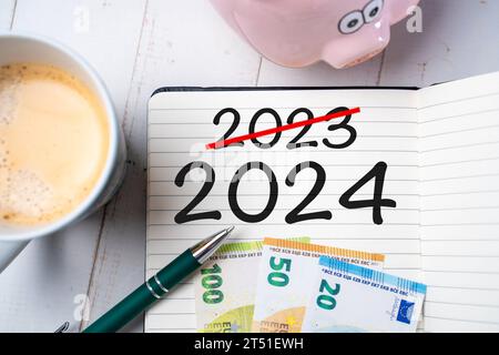 2 novembre 2023 : Neues Finanzjahr 2024, Notizblock mit der Zahl 2024 und 2023 auf einem Schreibtisch zusammen mit einem Sparschwein. Jahreswechsel und Änderungen Konzept FOTOMONTAGE *** nouvel exercice 2024, bloc-notes avec les numéros 2024 et 2023 sur un bureau avec une tirelire. Nouvelle année et changements au concept FOTOMONTAGE crédit : Imago/Alamy Live News Banque D'Images