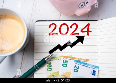 2 novembre 2023 : Neues Finanzjahr 2024, Notizblock mit der Zahl 2024 und einem ansteigenden Pfeil zusammen mit Bargeld auf einem Schreibtisch FOTOMONTAGE *** nouvel exercice financier 2024, bloc-notes avec le numéro 2024 et une flèche ascendante avec de l'argent sur un PHOTOMONTAGE de bureau crédit : Imago/Alamy Live News Banque D'Images