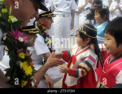 110813XG305-273 BUSAN, République de Corée (le 13 août 2011) commandant en chef David Unnone, commandant en chef du navire de commandement de la 7e flotte américaine USS Blue Ridge (LCC 19), capitaine Daniel Grieco, commandant de Blue Ridge, et le capitaine Charles Williams, chef d'état-major de la 7e flotte américaine, sont accueillis par des enfants coréens alors que Blue Ridge arrive à Busan pour participer à Uichi Freedom Guardian 2011. Marine Banque D'Images