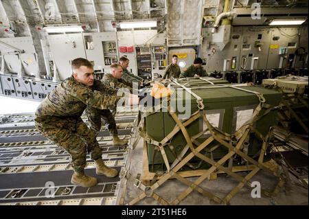 110325UI176-727 YOKOTA, Japon (25 mars 2011) des Marines et des aviateurs poussent une palette de fournitures à bord d'un avion C-17 Globemaster III après un vol vers la base aérienne du corps des Marines Iwakuni pour récupérer les Marines affectés à l'escadron de soutien des Marines (MWSS) 171. MWSS-171 se dirige vers l'aéroport de Sendai pour installer des douches portatives pour l'aide humanitaire au Japon dans le cadre de l'opération Tomodachi. (US Air Force Banque D'Images