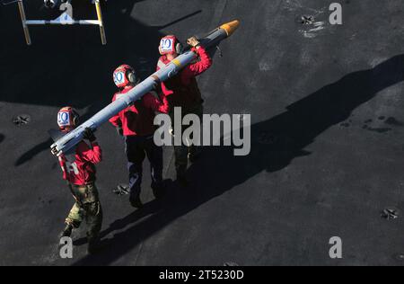 1103210074G-001 ARABIAN SEA (21 mars 2011) les hommes d'aviation affectés au porte-avions USS Enterprise (CVN 65) transportent un missile d'interception aérienne (AIM) d'un avion à un chariot de chargement. L’Enterprise et l’Escadre aérienne du transporteur (CVW) 1 sont déployés de routine pour mener des opérations de sécurité maritime dans la zone de responsabilité de la 5e flotte américaine. Marine Banque D'Images