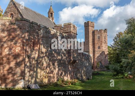 Maison attachée à une arche d'entrée d'un château avec lumière du soleil sur les murs Banque D'Images