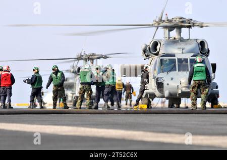 110322DM338-120 OCÉAN PACIFIQUE (22 mars 2011) des marins et des Marines chargent de la nourriture et des fournitures d'aide humanitaire sur un hélicoptère SH-60B Sea Hawk affecté au Battle Cats of Light Helicopter anti-Submarine Squadron (HSL) 43 à bord du porte-avions USS Ronald Reagan (CVN 76). Ronald Reagan opère au large des côtes du Japon et fournit une aide humanitaire conformément aux directives de l'opération Tomodachi. Marine Banque D'Images