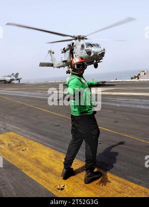 1009186362C-076 ARABIAN SEA (18 septembre 2010) l'aviateur Justin Rankin vérifie que la trajectoire de décollage d'un hélicoptère SH-60F Sea Hawk en vol stationnaire, affecté aux chiens poussiéreux de l'escadron anti-Submarine Helicopter Squadron (HS) 7, est exempte de personnel et d'équipement avant de signaler à l'hélicoptère de quitter le navire. Le HS-7 est déployé dans le cadre du Harry S. Truman Carrier Strike Group qui soutient les opérations de sécurité maritime et les efforts de coopération en matière de sécurité du théâtre dans la zone de responsabilité de la 5e flotte américaine. Marine Banque D'Images