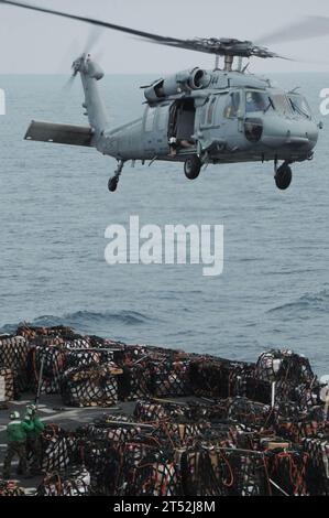 0910013038W-233 OCÉAN INDIEN (1 octobre 2009) un hélicoptère MH-60S Sea Hawk affecté aux Wildcards de l'hélicoptère Sea combat Squadron (HCS) 23 se prépare à soulever des marchandises du pont d'envol du navire de soutien de combat rapide USNS Bridge (T-AOE 10) au pont d'envol du porte-avions USS Nimitz (CVN 68) lors d'un réapprovisionnement en mer. Le Nimitz Carrier Strike Group est en déploiement de routine dans la zone de responsabilité de la 5e flotte américaine. Marine Banque D'Images