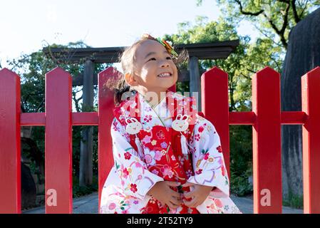 Une jeune fille heureuse portant un kimono japonais rouge Banque D'Images