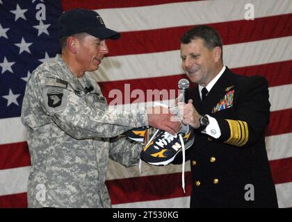 0912134142G-138 MANAMA, Bahreïn (13 décembre 2009) le vice-amiral Bill Gortney, commandant du Commandement central des forces navales des États-Unis, présente le général David H. Petraeus, commandant du Commandement central des États-Unis, une paire de chaussures de course bleu marine et or à l'activité de soutien naval Bahreïn. Petraeus a reçu les chaussures après que l'Académie navale américaine ait battu l'Académie militaire américaine lors du 110e match de football universitaire Army-Navy la nuit précédente. Banque D'Images