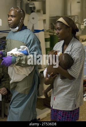 1001193165S-218 PORT-au-PRINCE, Haïti (19 janvier 2010) Une mère transporte son fils de neuf mois à bord du navire d'assaut amphibie polyvalent USS Bataan (LHD 5) après que l'enfant a été transporté par avion au navire pour y recevoir des soins médicaux. Bataan soutient l’opération Unified Response, une opération conjointe fournissant une aide humanitaire à la suite d’un tremblement de terre de magnitude 7,0 qui a dévasté la nation insulaire le 12 janvier 2010. Banque D'Images