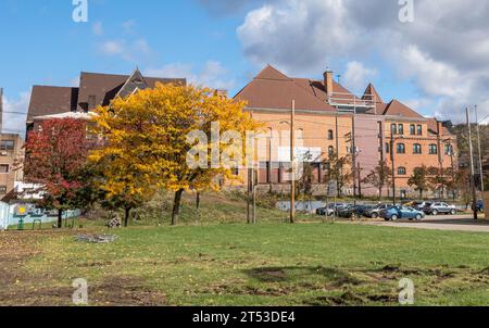 Une scène de rue avec la bibliothèque Carnegie au loin au-dessus d'un parking rempli sur Braddock Avenue à Braddock, Pennsylvanie, USA Banque D'Images