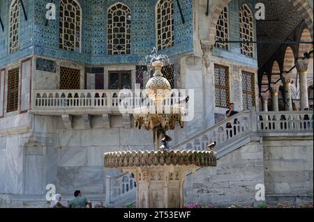 Fontaine dorée scintillante nichée dans les jardins luxuriants du palais de topkapi, avec des oiseaux qui bluffent et se rajeunissent dans ses eaux fraîches. Banque D'Images