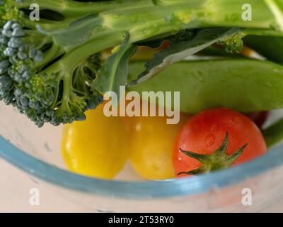 Un bol en verre de nourriture colorée, de légumes fraîchement cueillis dans le jardin Banque D'Images