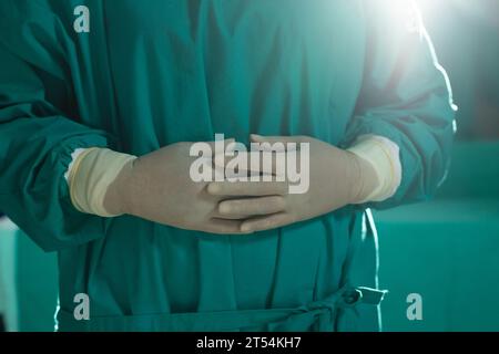 Section médiane d'une chirurgienne asiatique portant une blouse chirurgicale en salle d'opération à l'hôpital Banque D'Images
