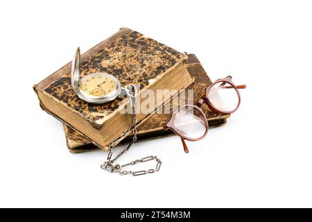 Vieux livres sur avec des lunettes et montre de poche isolé sur fond blanc Banque D'Images