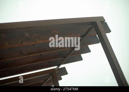 Le toit est en bois. Cadre en poutres d'acier et planches fendues. Détails de la structure du toit. Petite architecture. Banque D'Images