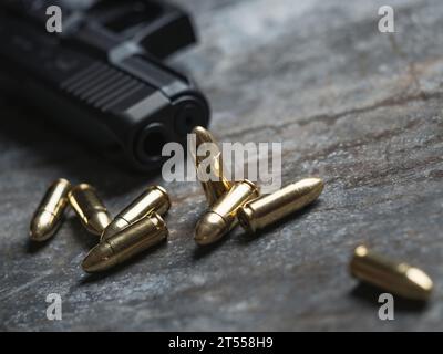 Pistolet à main avec munitions sur fond sombre. arme militaire pistolet 9 mm et tas de balles munitions à la table métallique. Banque D'Images