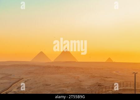 Les grandes Pyramides d'Egypte à l'aube. Paysage désertique, la seule merveille survivante du monde. Parapente au-dessus des pyramides. Banque D'Images