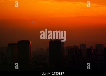 Un avion volant au coucher du soleil à l'aéroport de Noi Bai, Hanoi, Vietnam Banque D'Images