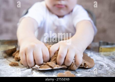 Un petit garçon fait des biscuits au gingembre dans la cuisine Banque D'Images