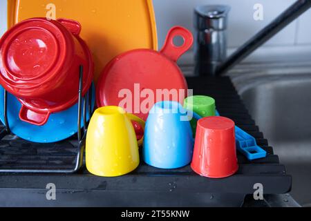 Vaisselle en plastique pour enfants lavée et couchée sur un évier Banque D'Images