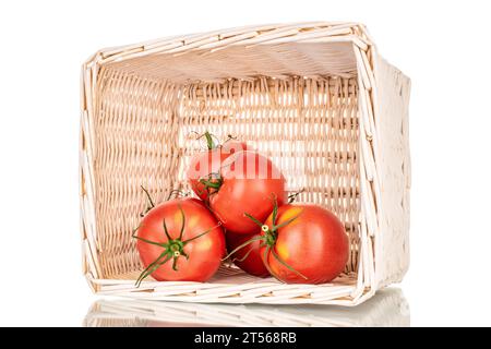 Plusieurs tomates juteuses roses dans un panier, macro, isolées sur fond blanc. Banque D'Images