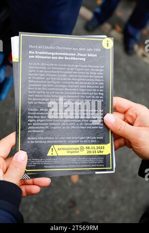 03 novembre 2023, Bavière, Röthenbach an Der Pegnitz : un policier tient le dépliant sur l'affaire froide de Claudia Obermeier. Les enquêteurs ont de nouvelles pistes et rouvrent l’enquête après plus de 33 ans. Le jeune homme de 22 ans a été victime d'un homicide à Röthenbach an der Pegnitz, dans le centre de la Franconie, en août 1990. Photo : Daniel Löb/dpa Banque D'Images