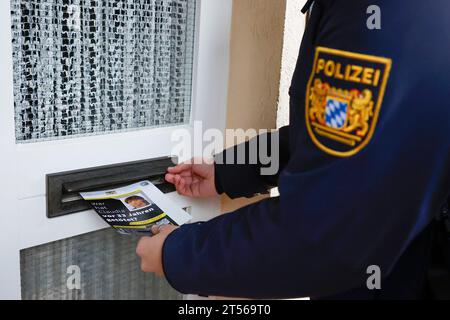 03 novembre 2023, Bavière, Röthenbach an Der Pegnitz : un officier de police met le dépliant sur l'affaire froide de Claudia Obermeier dans une boîte aux lettres. Les enquêteurs ont de nouvelles pistes et rouvrent l’enquête après plus de 33 ans. Le jeune homme de 22 ans a été victime d'un homicide en août 1990 à Röthenbach an der Pegnitz, dans le centre de la Franconie. Photo : Daniel Löb/dpa Banque D'Images