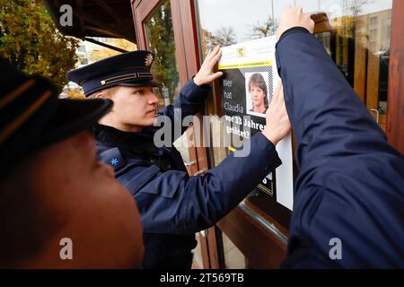 03 novembre 2023, Bavière, Röthenbach an Der Pegnitz : les policiers accrochent l'affiche de l'affaire froide de Claudia Obermeier sur une vitre. Les enquêteurs ont de nouvelles pistes et rouvrent l’enquête après plus de 33 ans. Le jeune homme de 22 ans a été victime d'un homicide en août 1990 à Röthenbach an der Pegnitz, dans le centre de la Franconie. Photo : Daniel Löb/dpa Banque D'Images