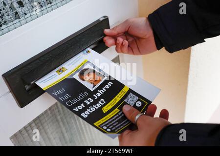 03 novembre 2023, Bavière, Röthenbach an Der Pegnitz : un officier de police met le dépliant sur l'affaire froide de Claudia Obermeier dans une boîte aux lettres. Les enquêteurs ont de nouvelles pistes et rouvrent l’enquête après plus de 33 ans. Le jeune homme de 22 ans a été victime d'un homicide en août 1990 à Röthenbach an der Pegnitz, dans le centre de la Franconie. Photo : Daniel Löb/dpa Banque D'Images