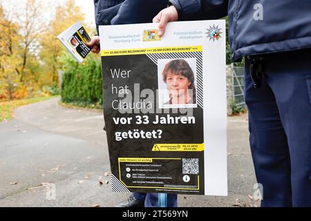 03 novembre 2023, Bavière, Röthenbach an Der Pegnitz : un policier tient l'affiche de l'affaire froide de Claudia Obermeier. Les enquêteurs ont de nouvelles pistes et rouvrent l’enquête après plus de 33 ans. Le jeune homme de 22 ans a été victime d'un homicide à Röthenbach an der Pegnitz, dans le centre de la Franconie, en août 1990. Photo : Daniel Löb/dpa Banque D'Images