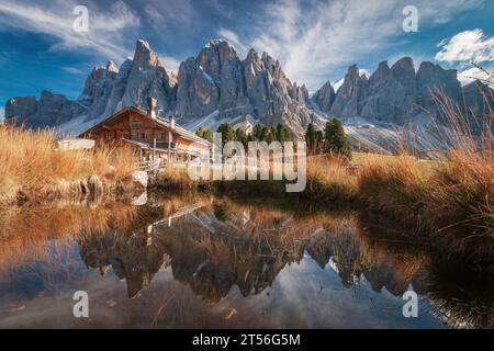 Vue panoramique de Geisler Alm Rifugio delle Odle en face des montagnes dolomites et reflet dans l'eau d'un étang, Tyrol du Sud, Italie Banque D'Images