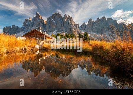 Vue panoramique de Geisler Alm Rifugio delle Odle en face des montagnes dolomites et reflet dans l'eau d'un étang, Tyrol du Sud, Italie Banque D'Images