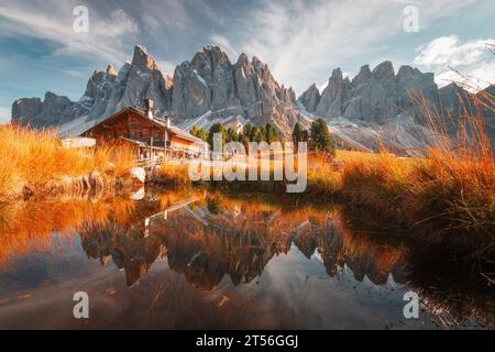 Vue panoramique de Geisler Alm Rifugio delle Odle en face des montagnes dolomites et reflet dans l'eau d'un étang, Tyrol du Sud, Italie Banque D'Images