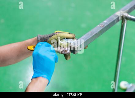 Fermer la main main main main peinture liquide enlever le soudage à l'arc après le soudage de l'acier inoxydable. Banque D'Images