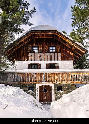 Vue frontale d'une maison de village traditionnelle des alpes pendant la neige d'hiver, Carinthie, Autriche Banque D'Images