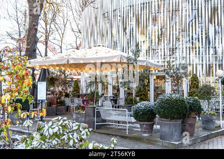 Café de rue confortable avec des tables vides sur une journée d'hiver enneigée à Tivoli, Copenhague Danemark Banque D'Images