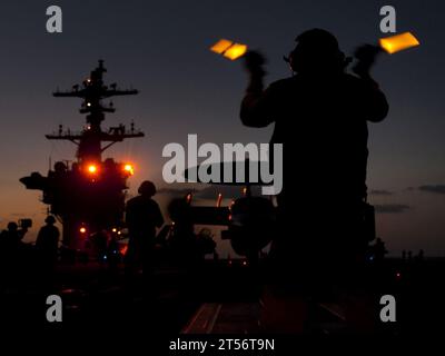 Le directeur de l'avion guide un E-2C Hawkeye affecté au porte-avions Airborne Early Warning and Control Squadron (VAW) 125 sur les catapultes de proue à bord du porte-avions de classe Nimitz USS Carl Vinson (CVN 70). Le Carl Vinson Carrier Strike Group, Navy, U.S. Navy Banque D'Images