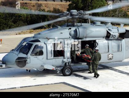Les équipiers de l'US Navy Air chargent un mannequin d'entraînement sur un hélicoptère MH-60S Sea Hawk affecté aux Blackjacks de l'hélicoptère Sea C.jpg Banque D'Images