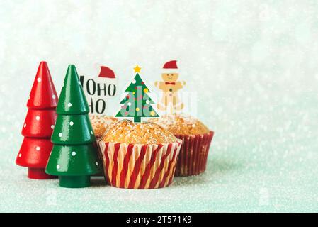 Muffins de noël faits maison avec des signes de Noël amusants et des arbres de noël sur un fond bleu. Concept doux de Noël Banque D'Images