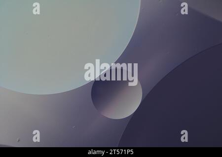 Vue de dessus les bulles d'huile tombent sur l'eau avec fond coloré, concept de photographie macro Banque D'Images