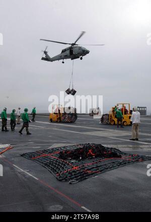 Des marins de la marine AMÉRICAINE se tiennent sur le pont d'envol de l'USS George Washington (CVN 73) alors qu'un hélicoptère HH-60H Sea Hawk dépose de la cargaison de l'USNS Henry J. Kaiser (T-AO 187) lors d'un réapprovisionnement vertical à sea.jpg h 30 Banque D'Images